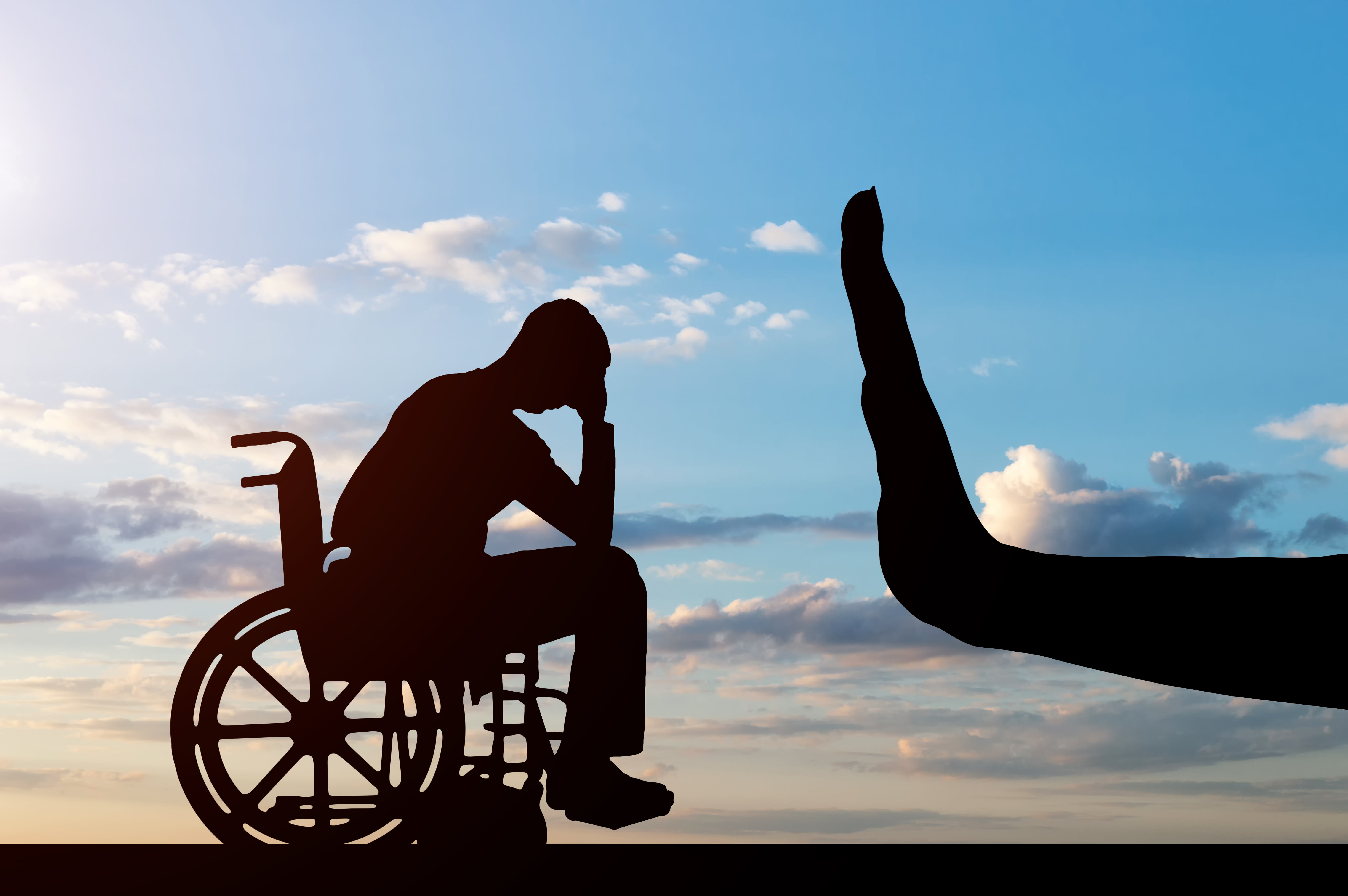 Silhouette of man in wheelchair with a silhouette of a hand held out in front of him