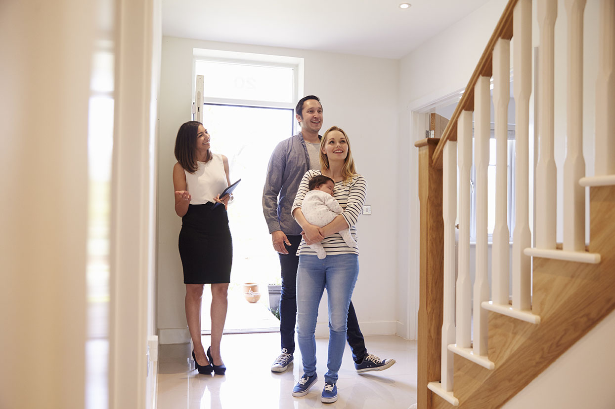 Couple with baby being shown a home