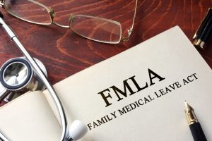 FMLA paperwork, eyeglasses, and stethoscope on a table 