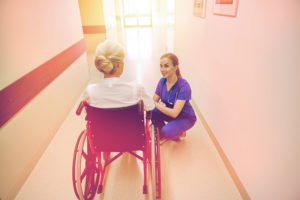 Nurse helping a lady in a wheelchair
